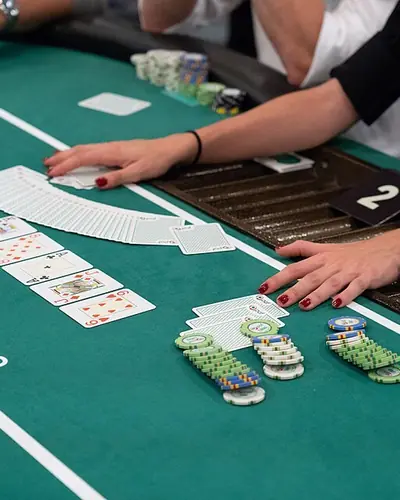 Croupier che distribuisce le carte al tavolo verde
